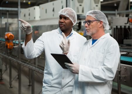 Male workers inspecting products in cold drink factory